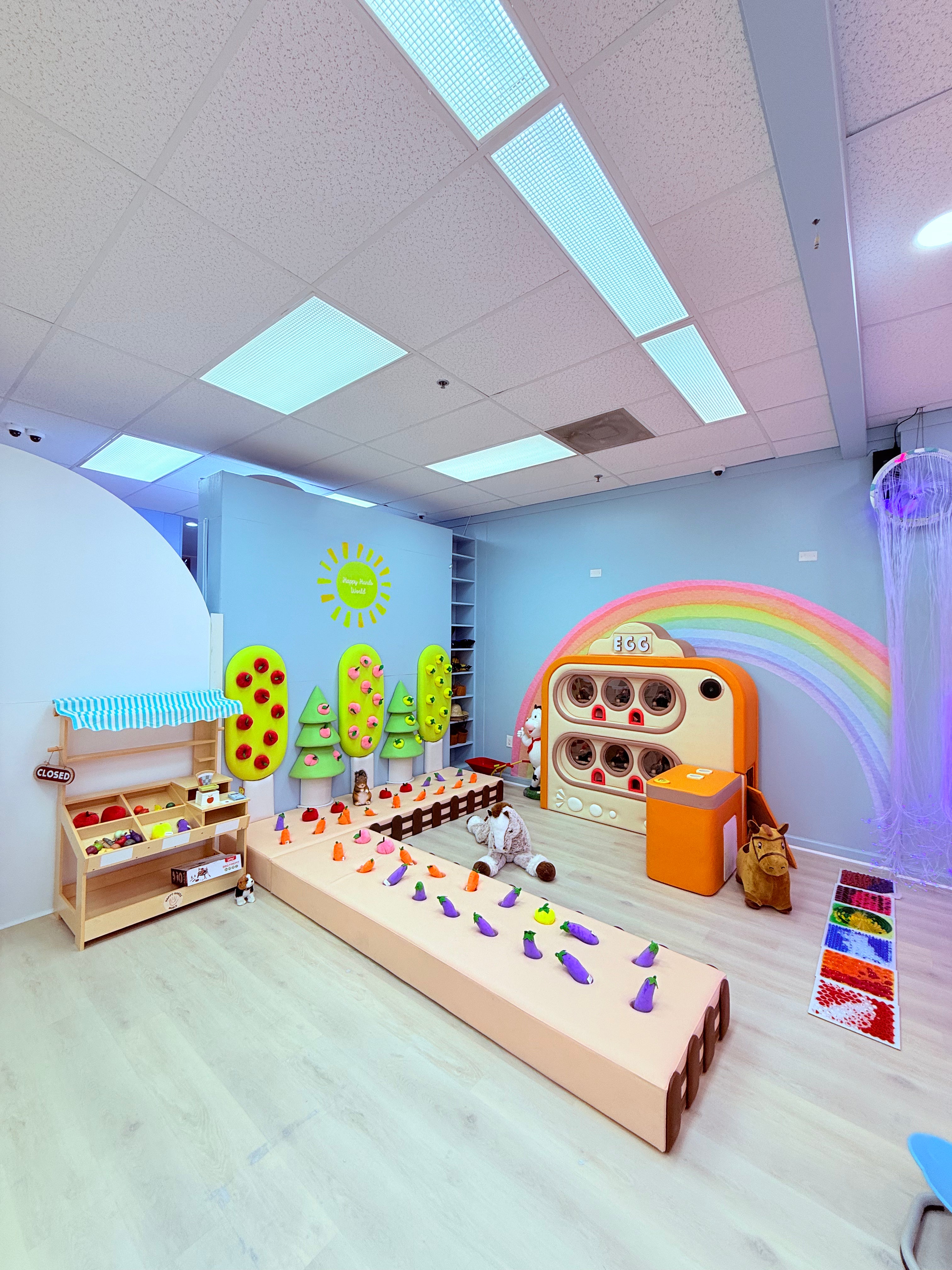 Children's playroom with colorful toys and educational equipment on a light wood floor.
