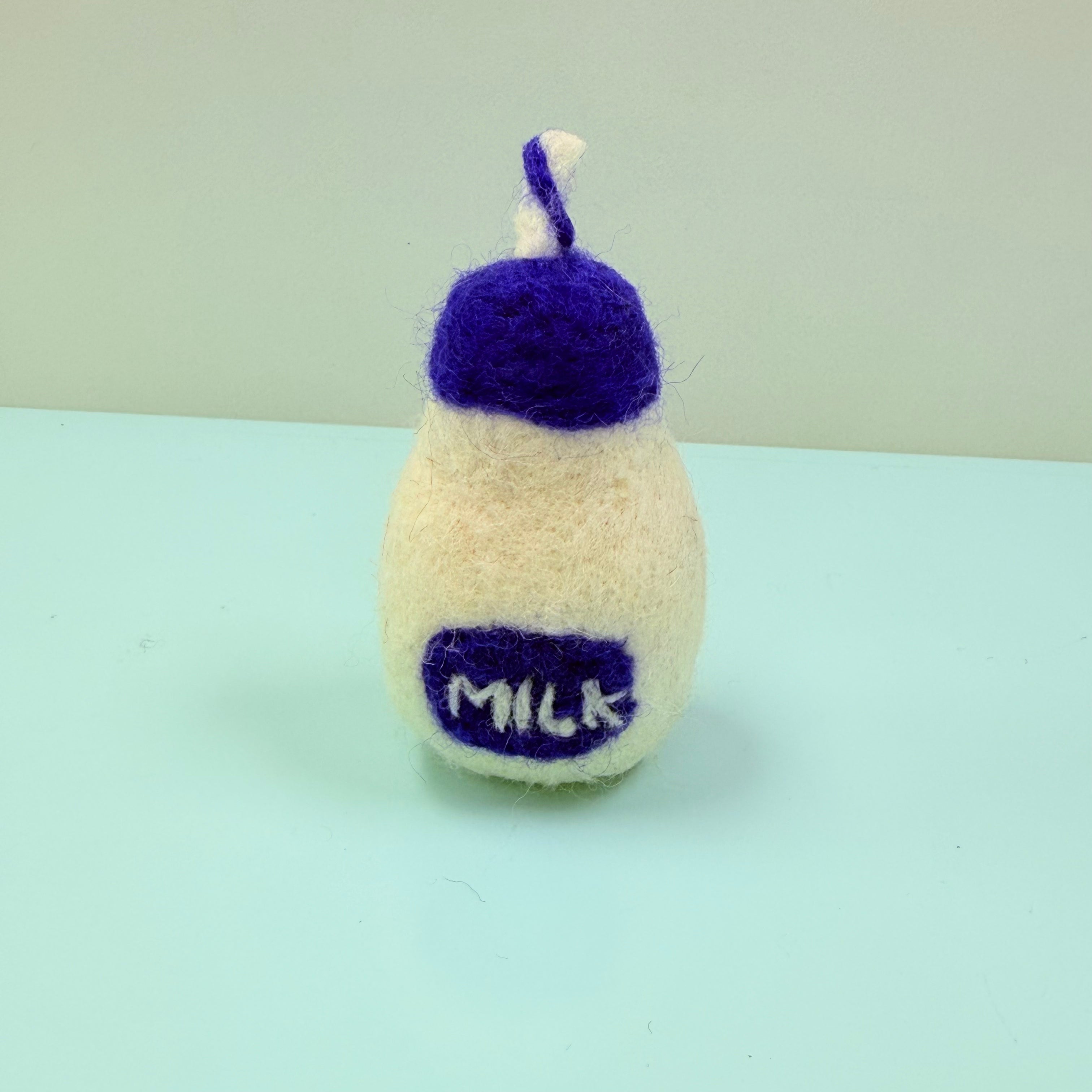 Knitted milk bottle toy with purple
