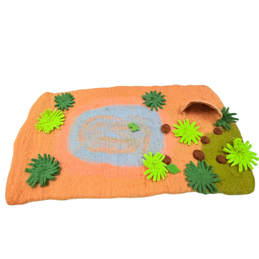 Felt play mat with animal shapes and greenery on an orange background