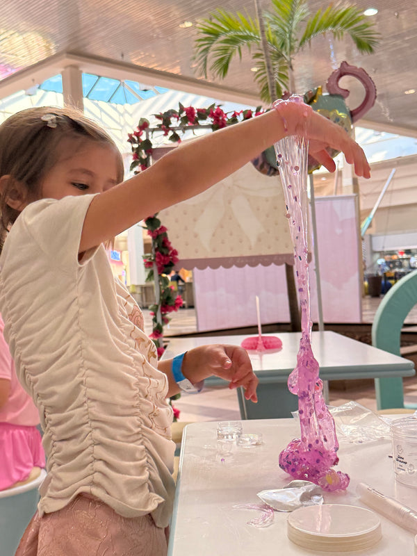 Child playing with a pink toy in a decorated room