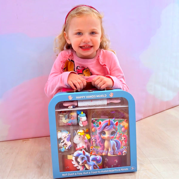 Child holding a toy set packaging with a unicorn design on a pink background