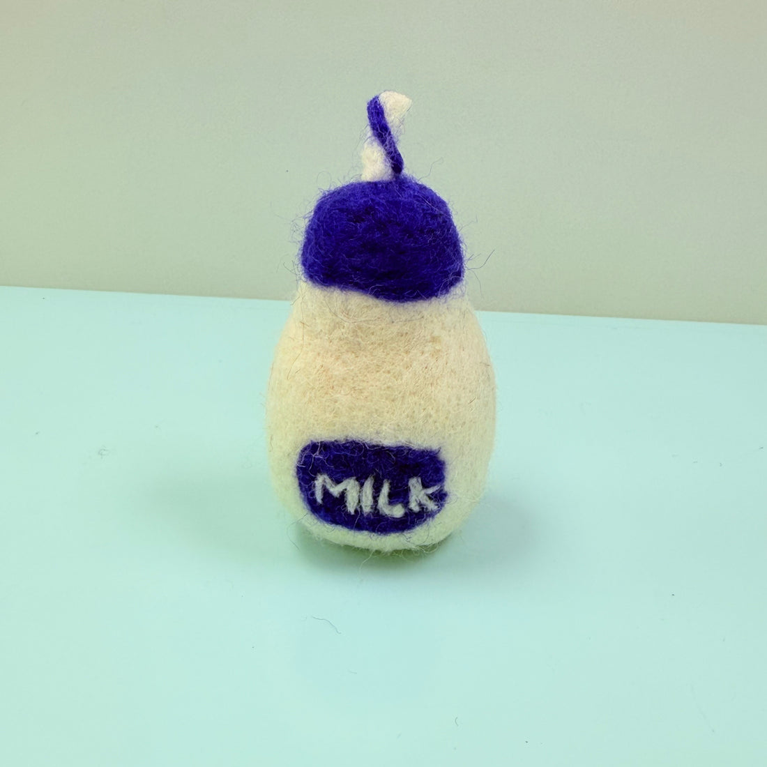 Knitted milk bottle toy with purple