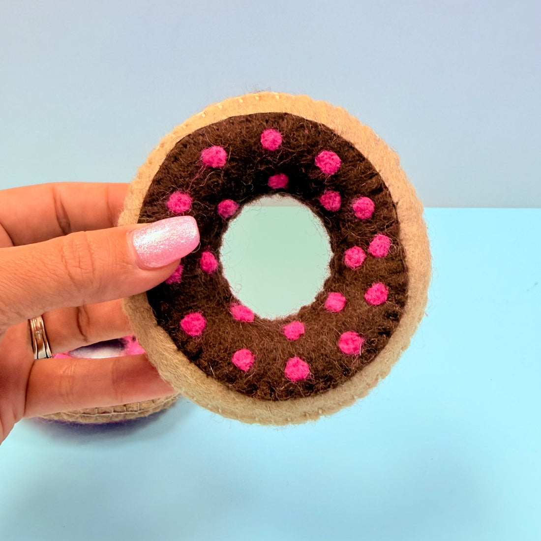 Hand holding a donut-shaped craft item