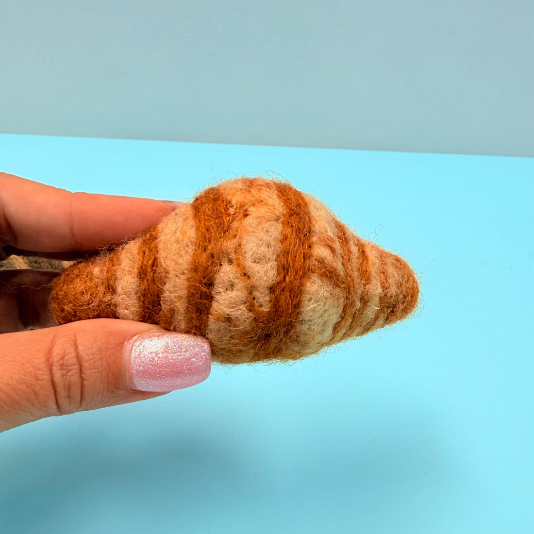 Hand holding a small felted wool
