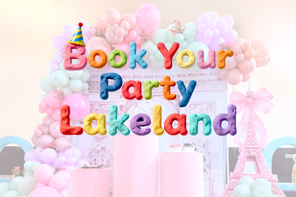Colorful balloon arch with 'Book Your Party Lakeland' text on a light background